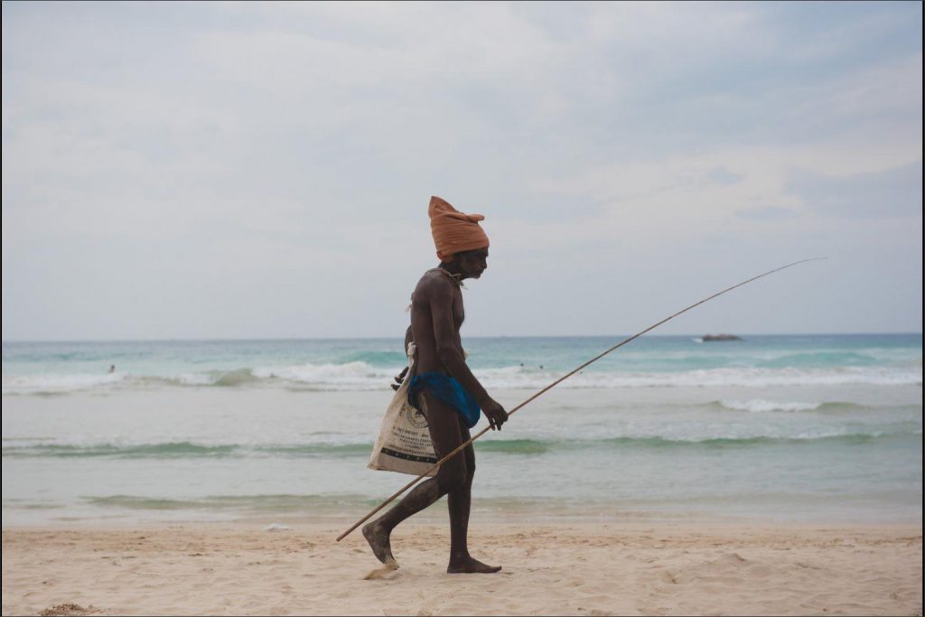 Sri Lanka photographer: fisherman passing on the sandy beach.
