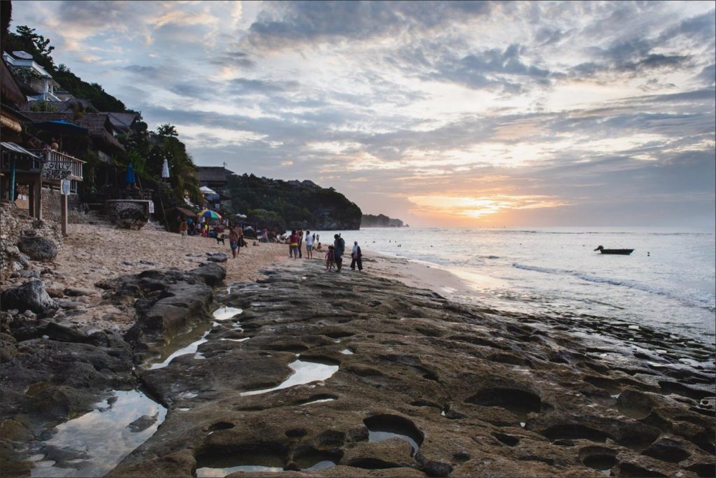 Bali Uluwatu wedding: sunset on rocky beach with the lush vegitation.