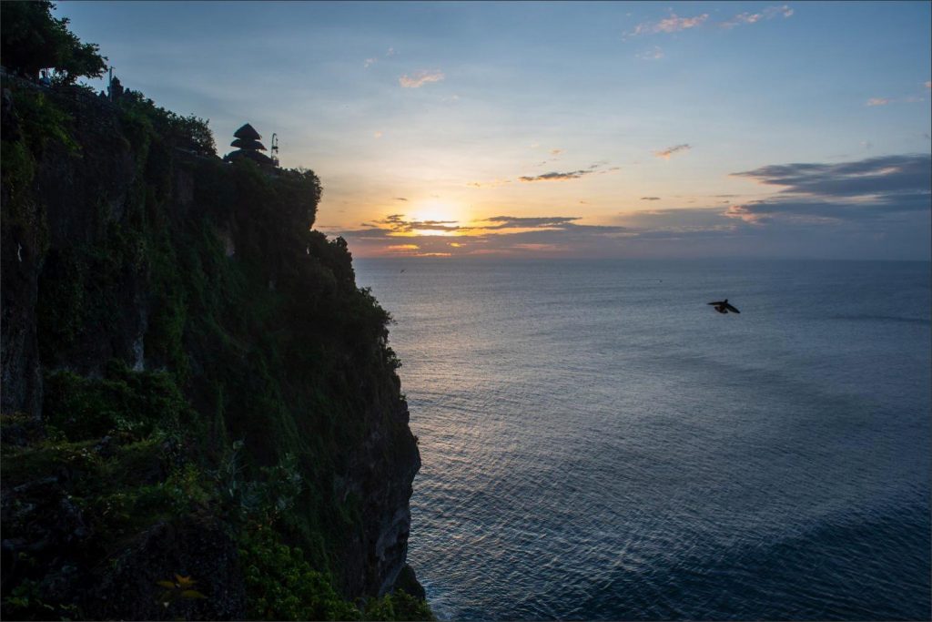Bali Uluwatu wedding: mesmerising sunset with the temple towering the cliffs and water.