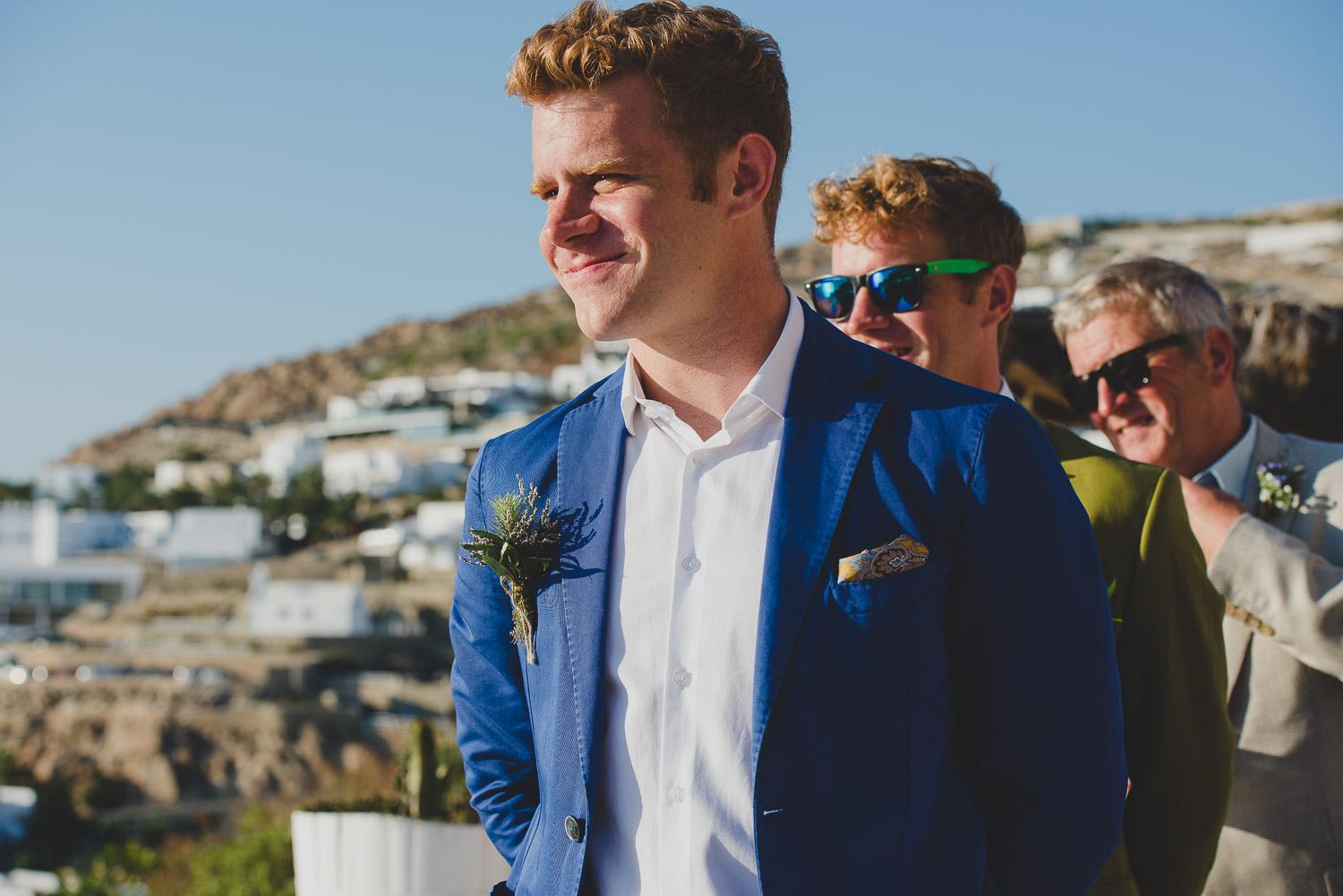 Wedding photographer Mykonos: smiling groom waiting at the church during Mykonos wedding.