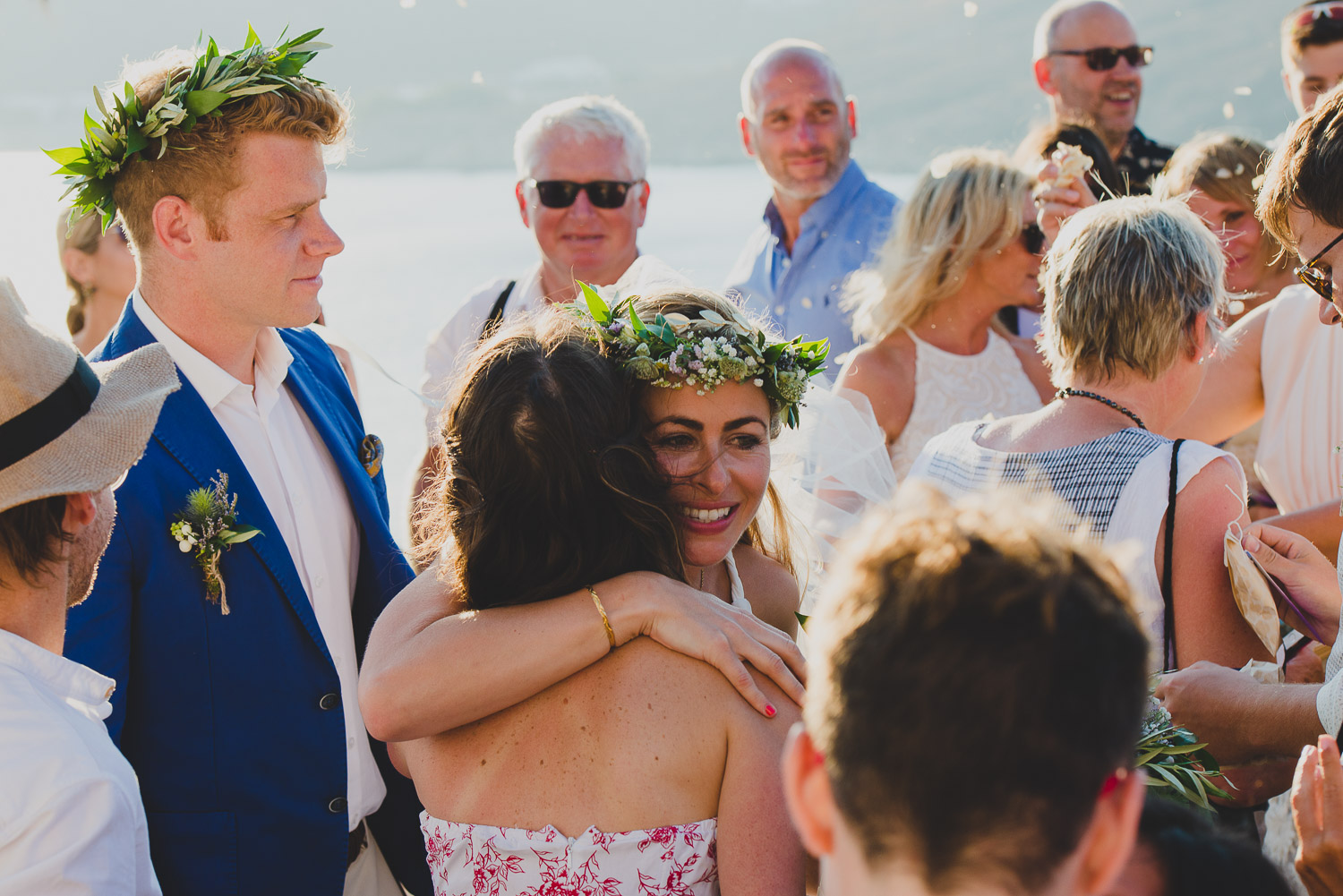 Wedding photographer Mykonos: bride hugs a friend at Mykonos wedding.
