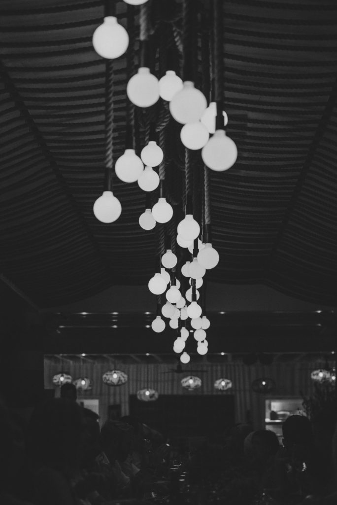 Wedding photographer Mykonos: black and white photo of wedding lights and decor at Elia for Mykonos wedding.
