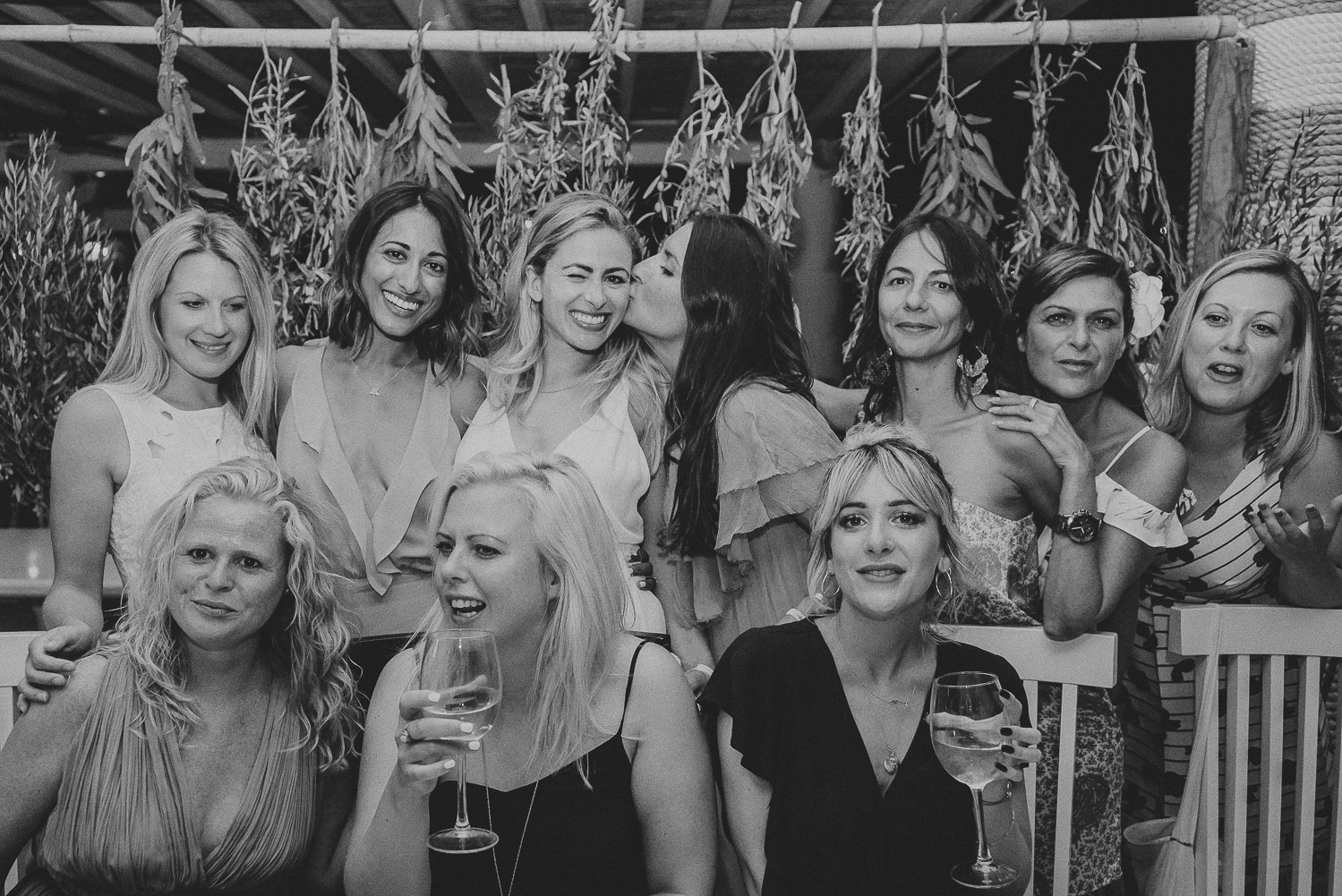 Wedding photographer Mykonos: black and white photo of the bride with her besties at Elia for her Mykonos wedding.