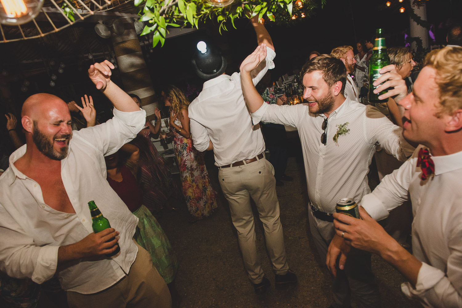 Wedding photographer Mykonos: men jumping on the dance floor at Elia during Mykonos wedding.