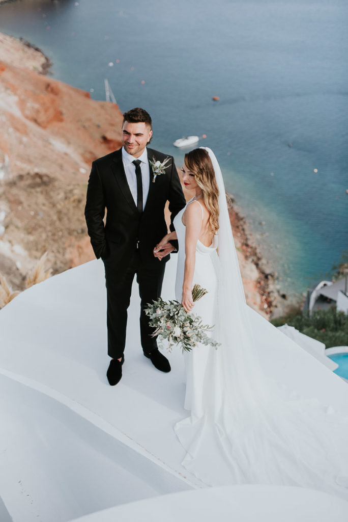 Santorini elopement photographer: first look with the caldera views by Ben and Vesna.