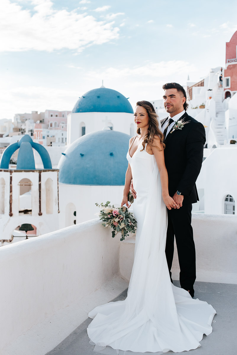 Santorini elopement photographer: couple with the blue domes by Ben and Vesna.