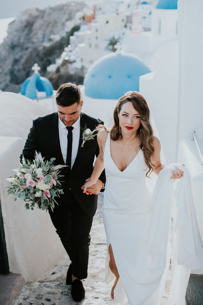 Santorini elopement photographer: couple and the blue domes by Ben and Vesna.