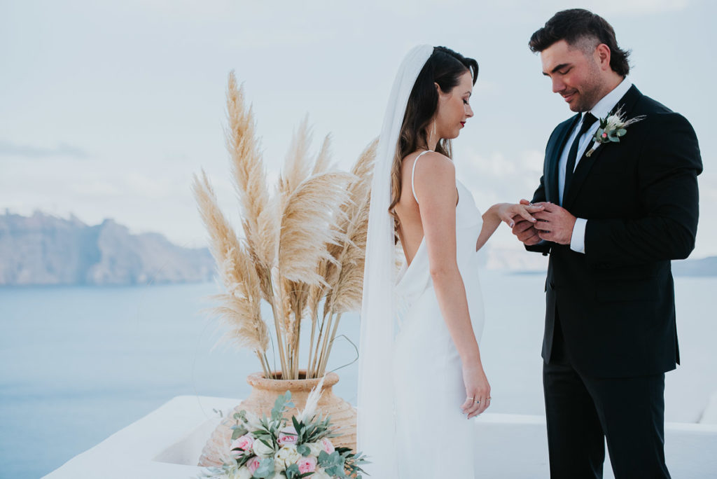 Santorini elopement photographer: couple with their rings by Ben and Vesna.