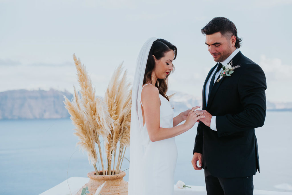 Santorini elopement photographer: couple with their rings by Ben and Vesna.