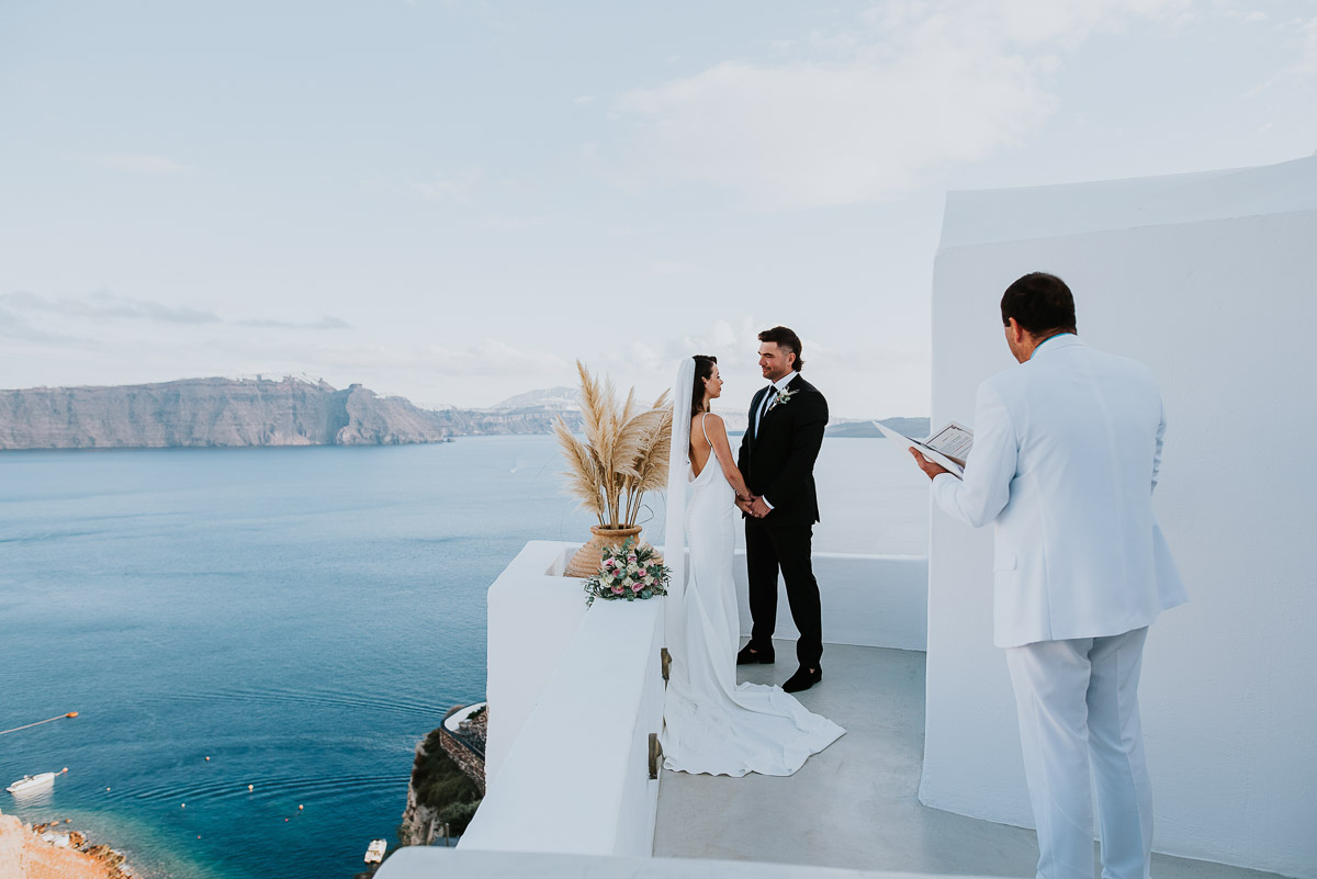 Santorini elopement photographer: couple at their wedding ceremony by Ben and Vesna.