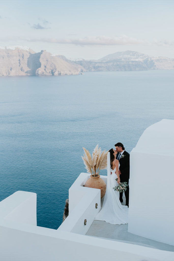 Santorini elopement photographer: couple and the white washed buildings by Ben and Vesna.