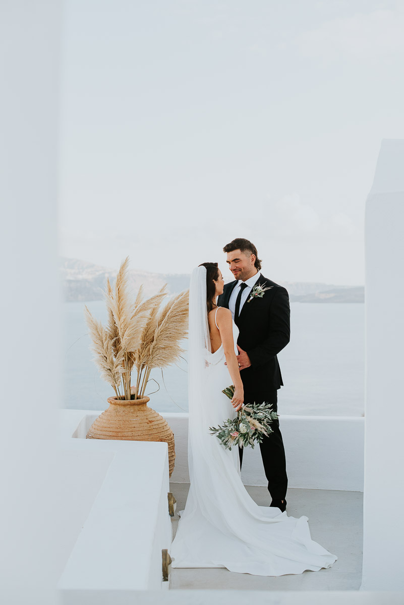 Santorini elopement photographer: couple and the white washed buildings by Ben and Vesna.