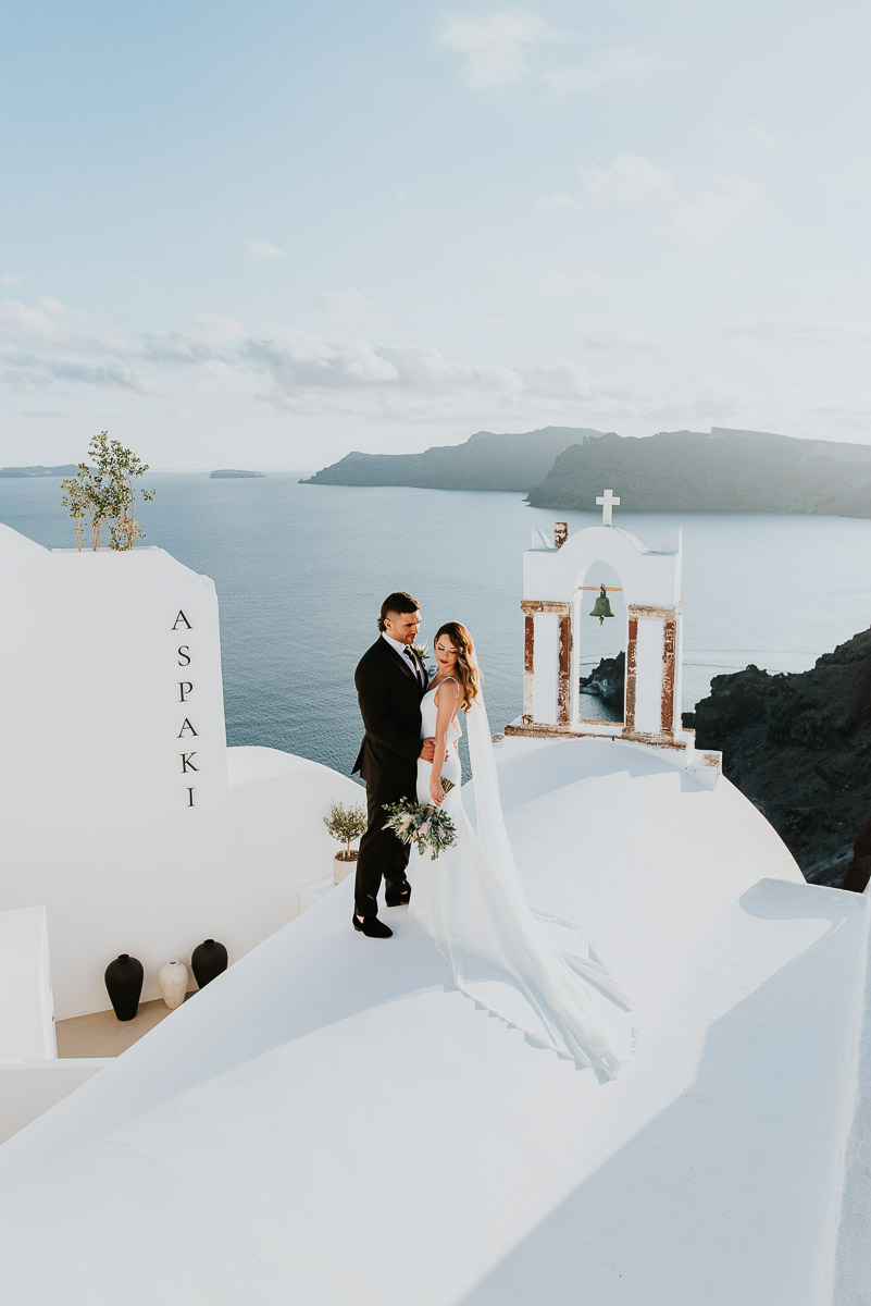 Santorini elopement photographer: couple with the bell tower by Ben and Vesna.