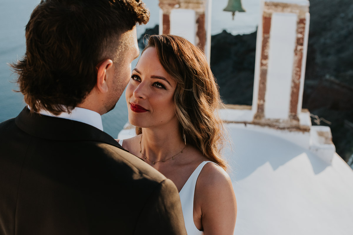 Santorini elopement photographer: close up of the couple with the bell towers by Ben and Vesna.