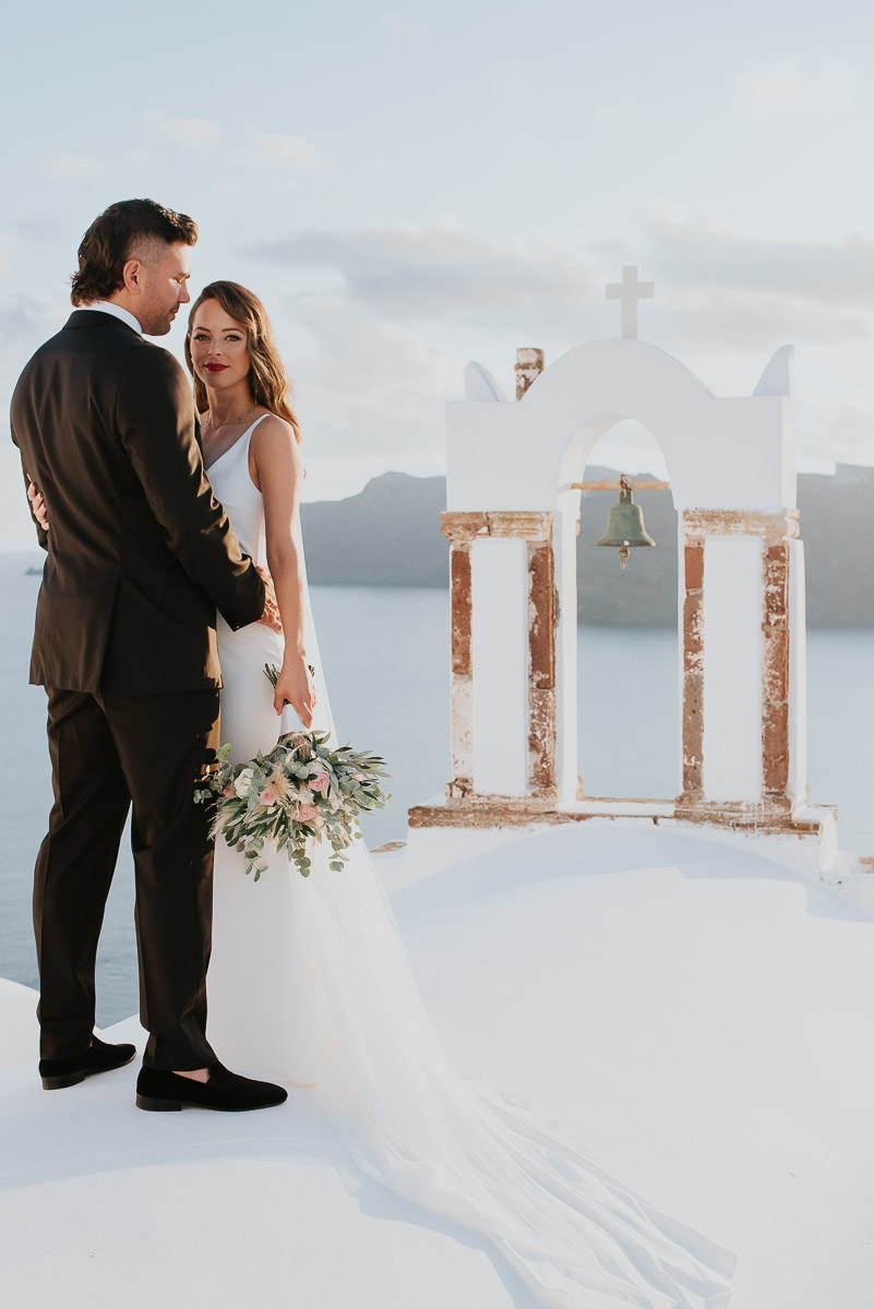 Santorini elopement photographer: couple with the bell towers by Ben and Vesna.