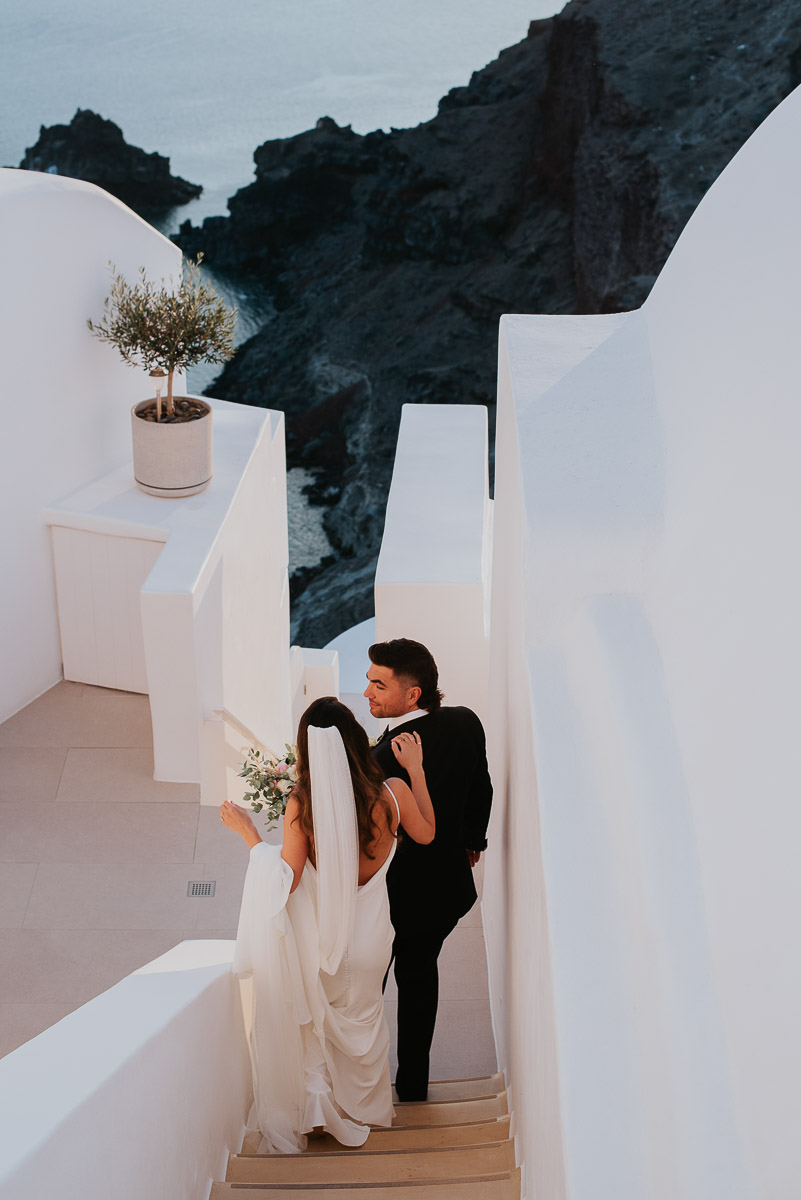 Santorini elopement photographer: couple waling down the stairs by Ben and Vesna.