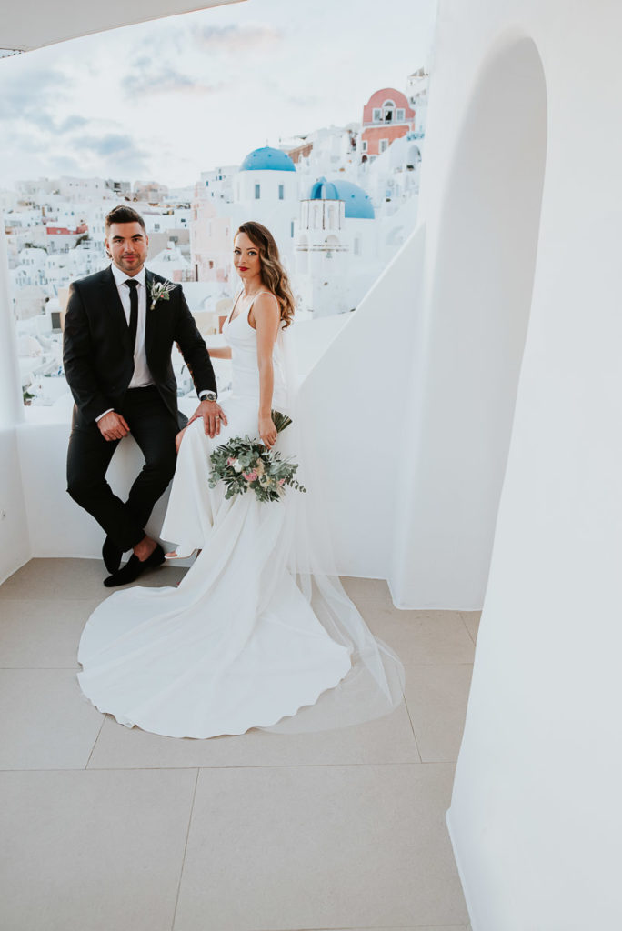 Santorini elopement photographer: couple with the blue domes by Ben and Vesna.