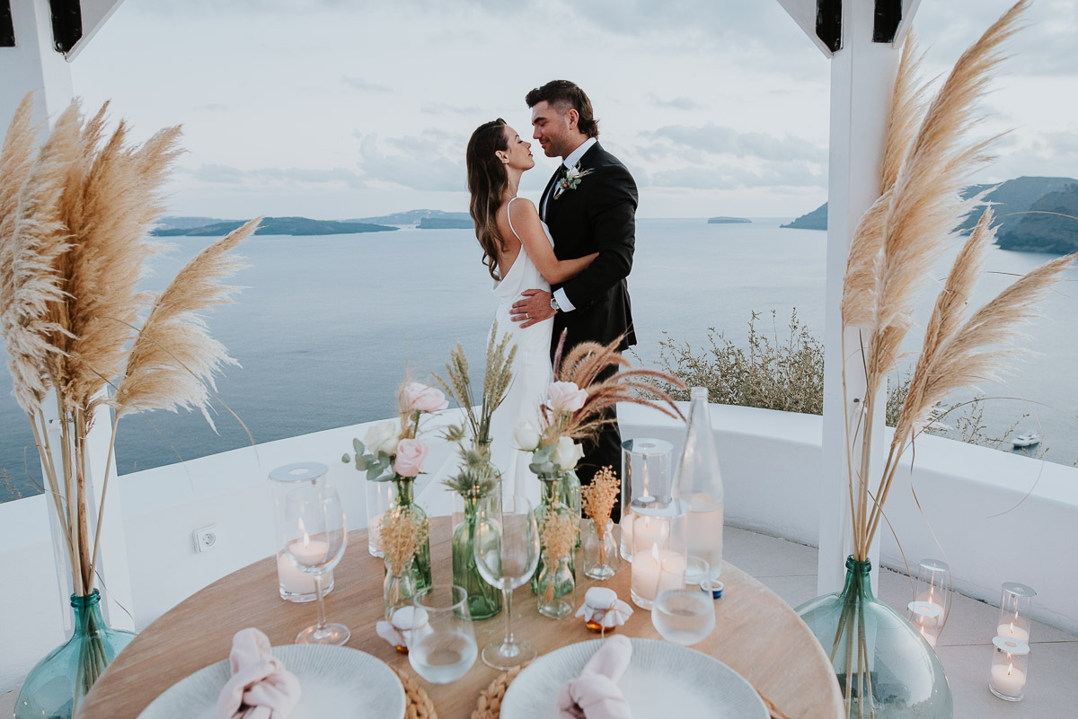 Santorini elopement photographer: couple with the views and the dinner by Ben and Vesna.
