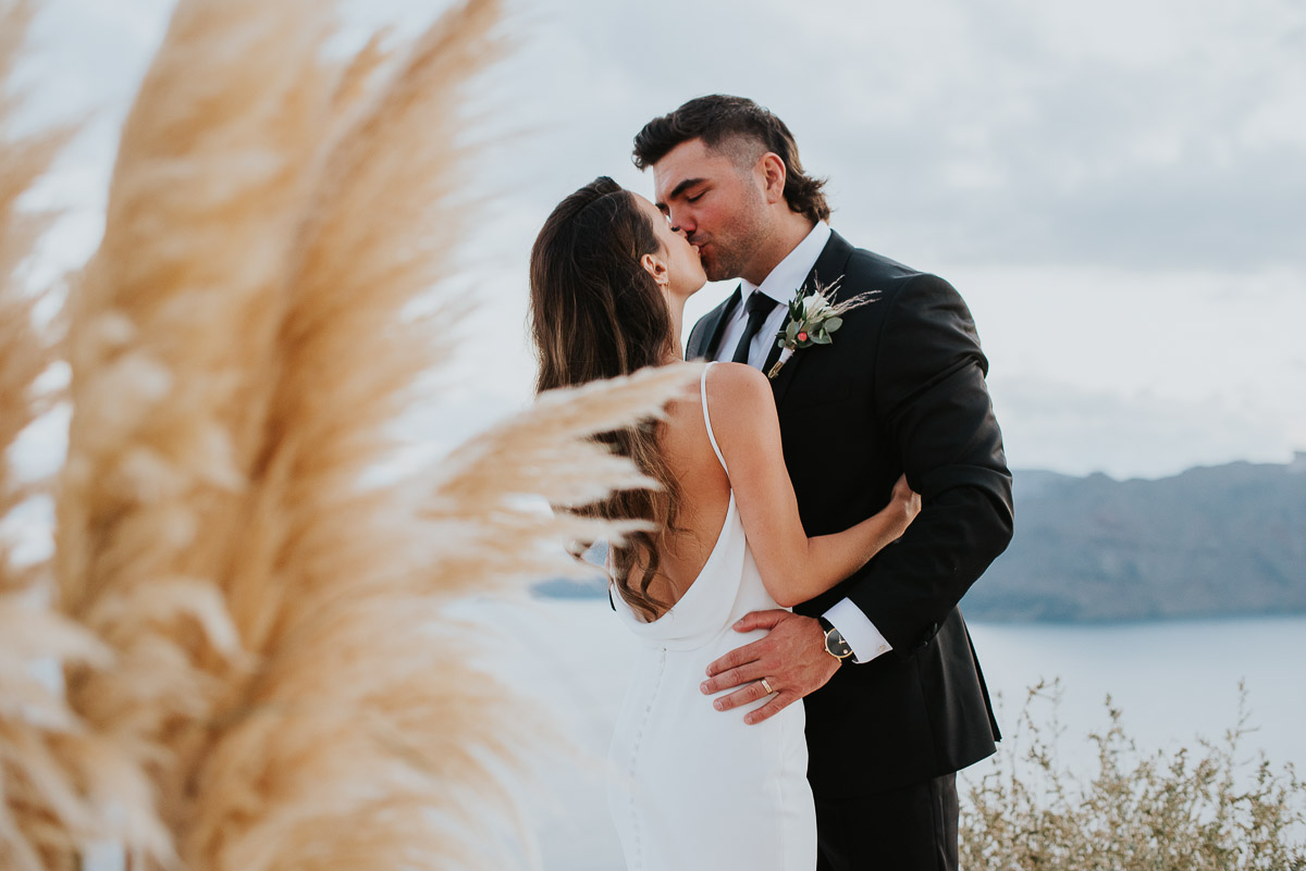 Santorini elopement photographer: couple kissing by Ben and Vesna.