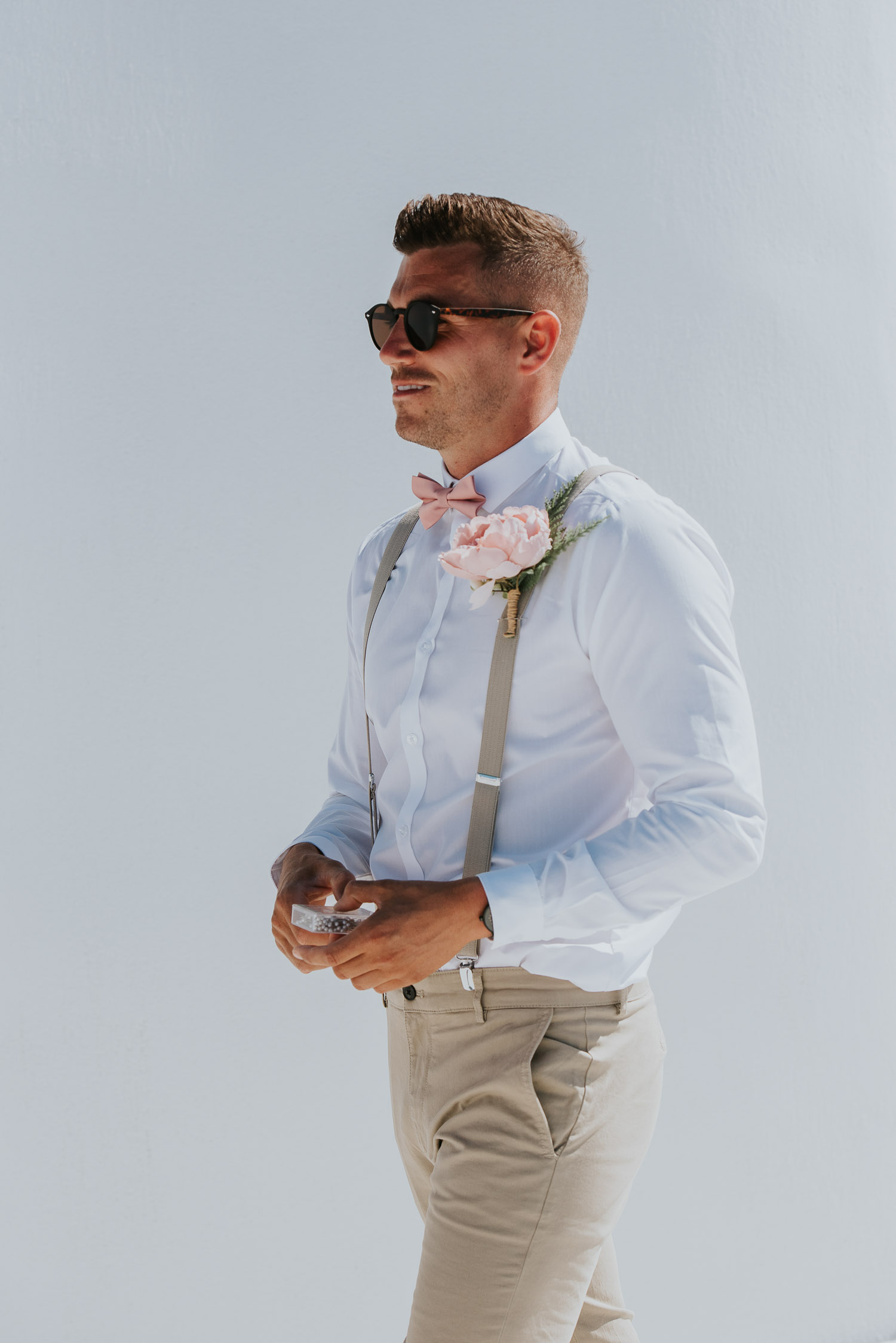 Wedding photographer Santorini: groom walking to the ceremony terrace by Ben and Vesna.