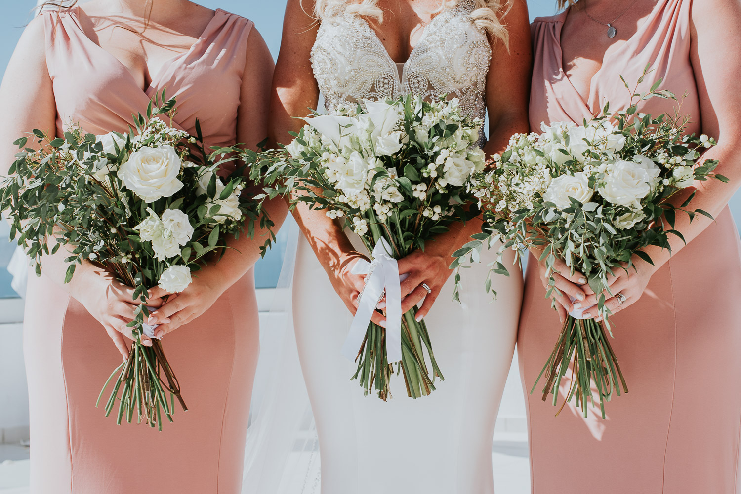 Wedding photographer Santorini: close up of the bride and her bridesmaids holding their beautiful bouquets by Ben and Vesna.