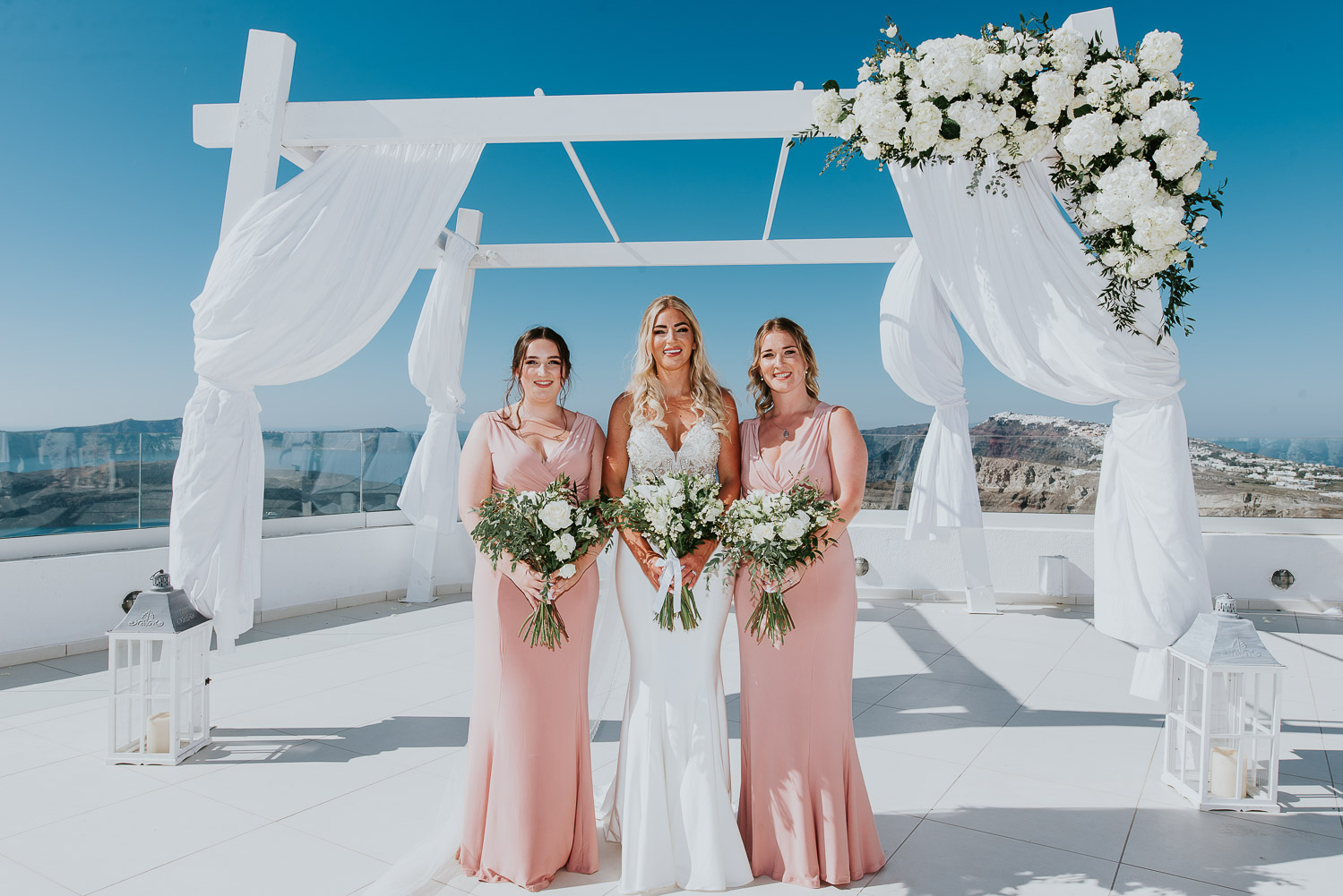 Wedding photographer Santorini: bride and her bridesmaids holding their beautiful bouquets by Ben and Vesna.