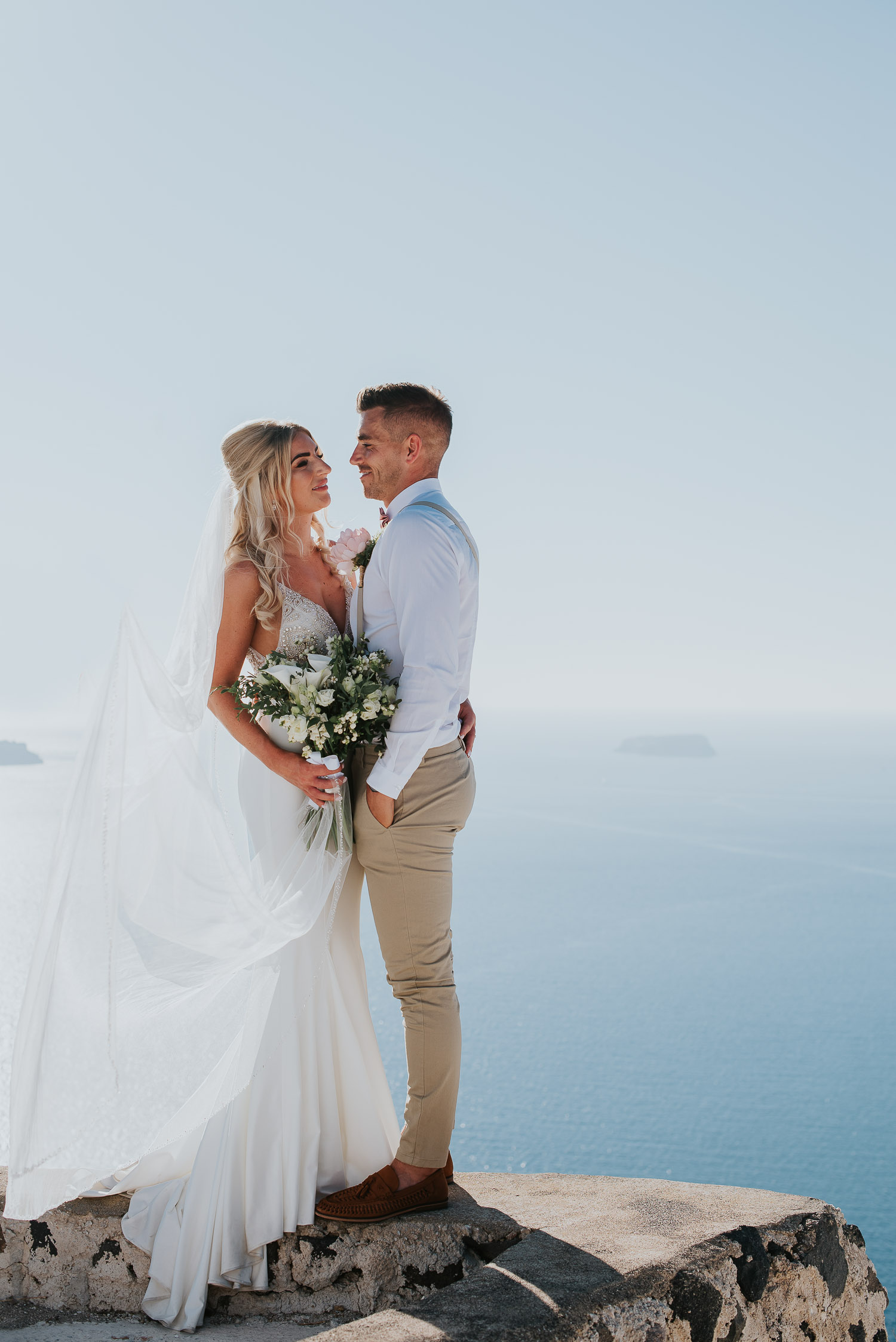 Wedding photographer Santorini: close up of bride and groom surrounded by the sea and the sky by Ben and Vesna.