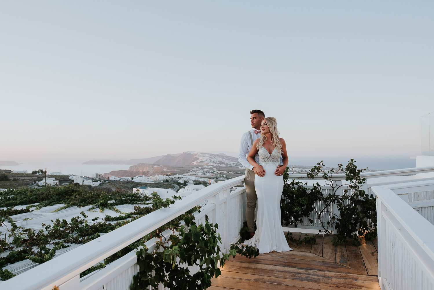 Wedding photographer Santorini: bride and groom on the bridge surrounded by vineyards and the caldera in the background by Ben and Vesna.