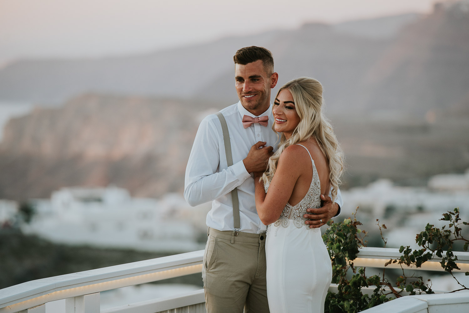 Wedding photographer Santorini: close up of bride and groom on the bridge holding hands embraced by Ben and Vesna.