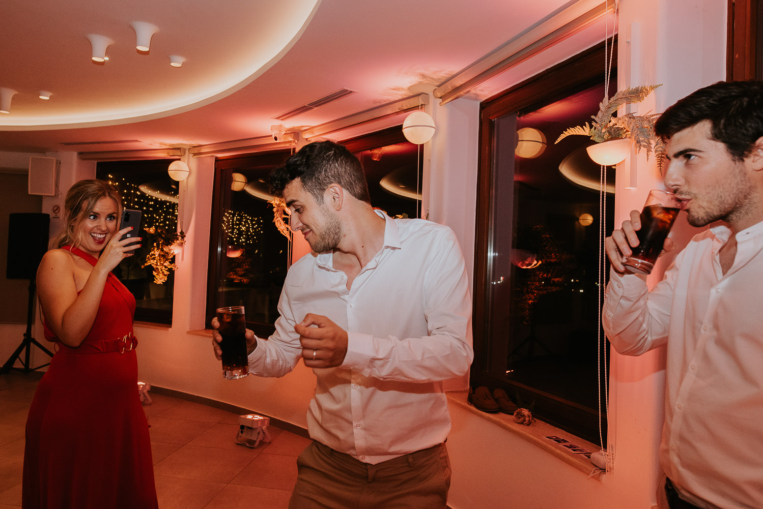 Wedding photographer Santorini: guests dancing and having drinks on the dance floor by Ben and Vesna.