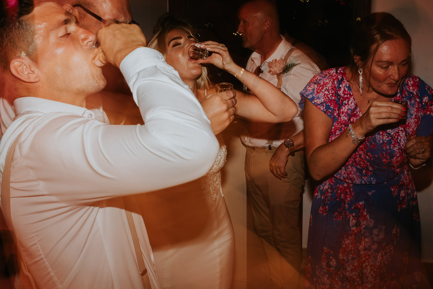 Wedding photographer Santorini: bride and groom drinking shots on the dance floor by Ben and Vesna.