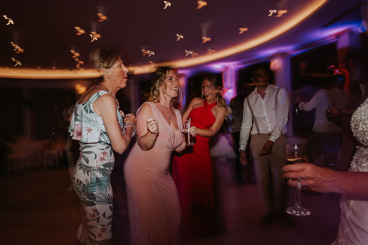 Wedding photographer Santorini: wedding guests singing and moving on dance floor by Ben and Vesna.