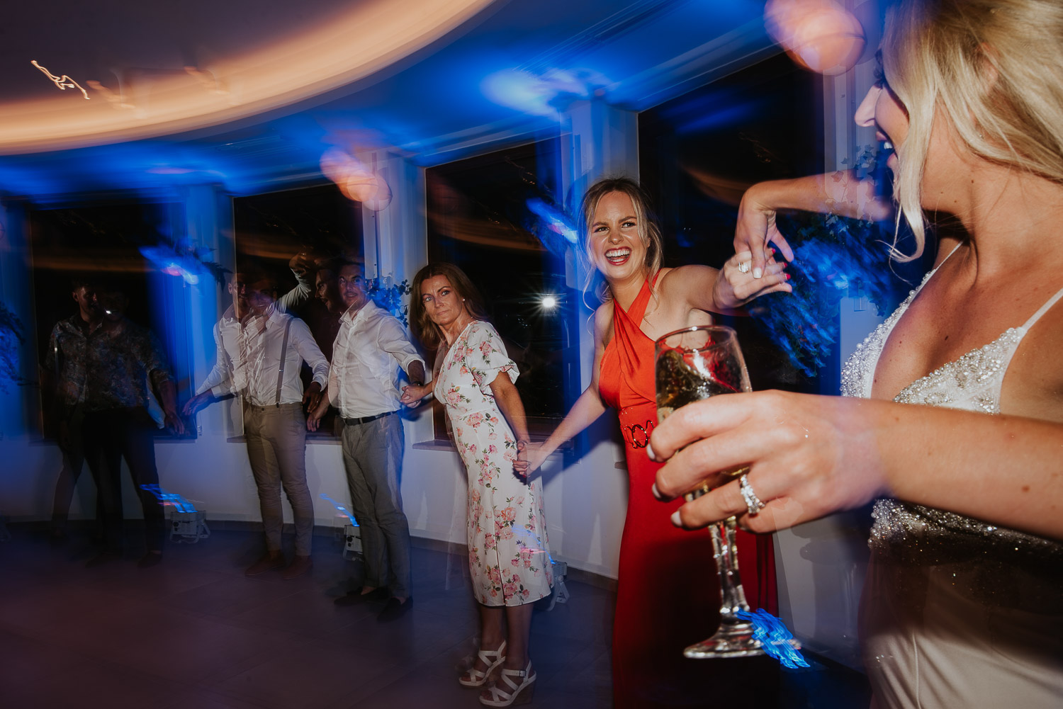 Wedding photographer Santorini: bride and the guests making wave on the dance floor by Ben and Vesna.