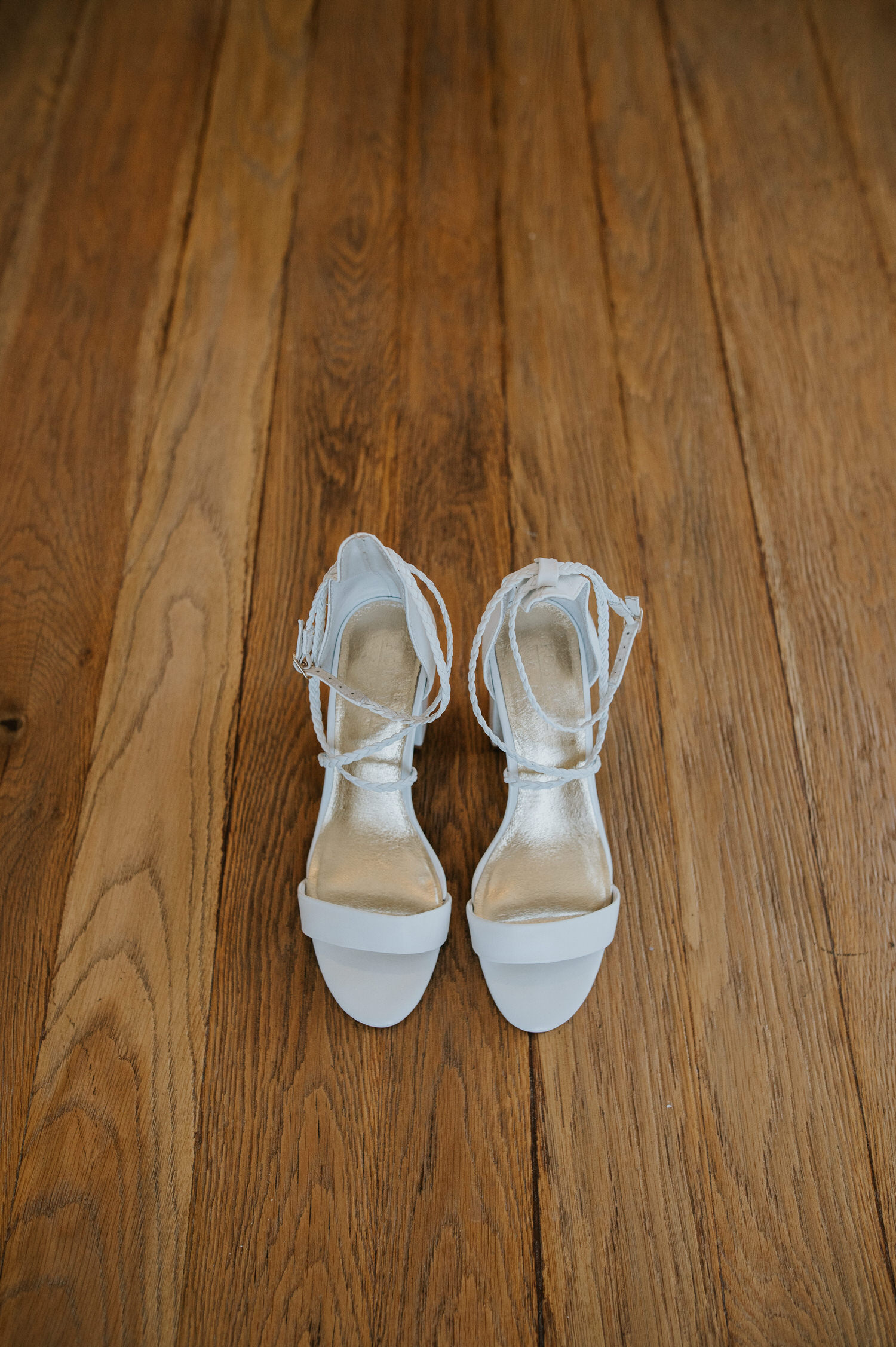 Mykonos wedding photographer: wedding sandals on the wooden table top.