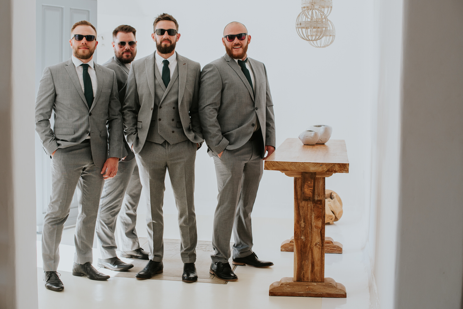 Mykonos wedding photographer: groom and his best men portrait with the sunglasses in the villa before the ceremony.