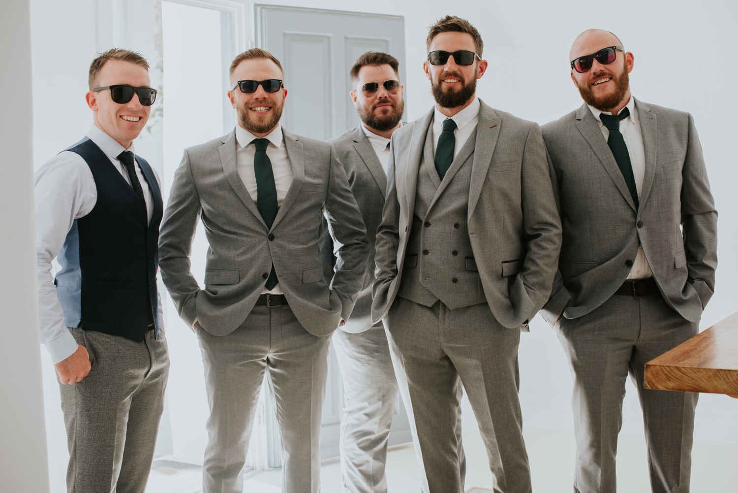 Mykonos wedding photographer: groom and his men portrait with the sunglasses in the villa before the ceremony.