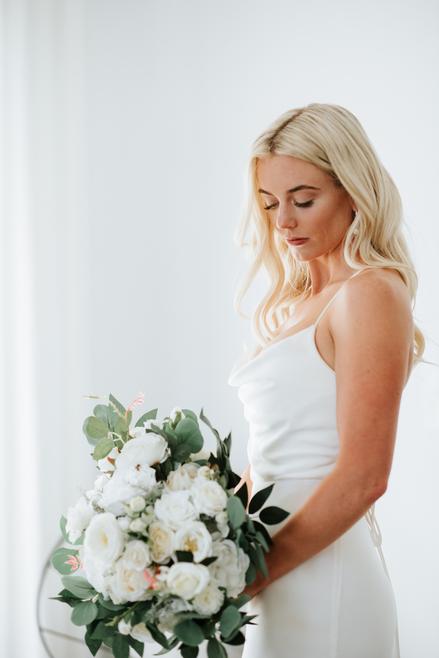 Mykonos wedding photographer: stunning close up of bride looking down at the bouquet she is holding.