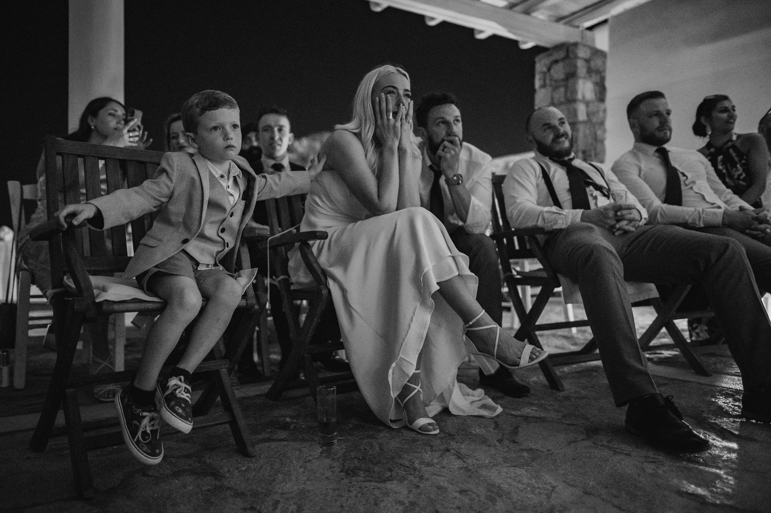 Mykonos wedding photographer: black and white photo of bride's nephew putting a comforting hand as she cries.