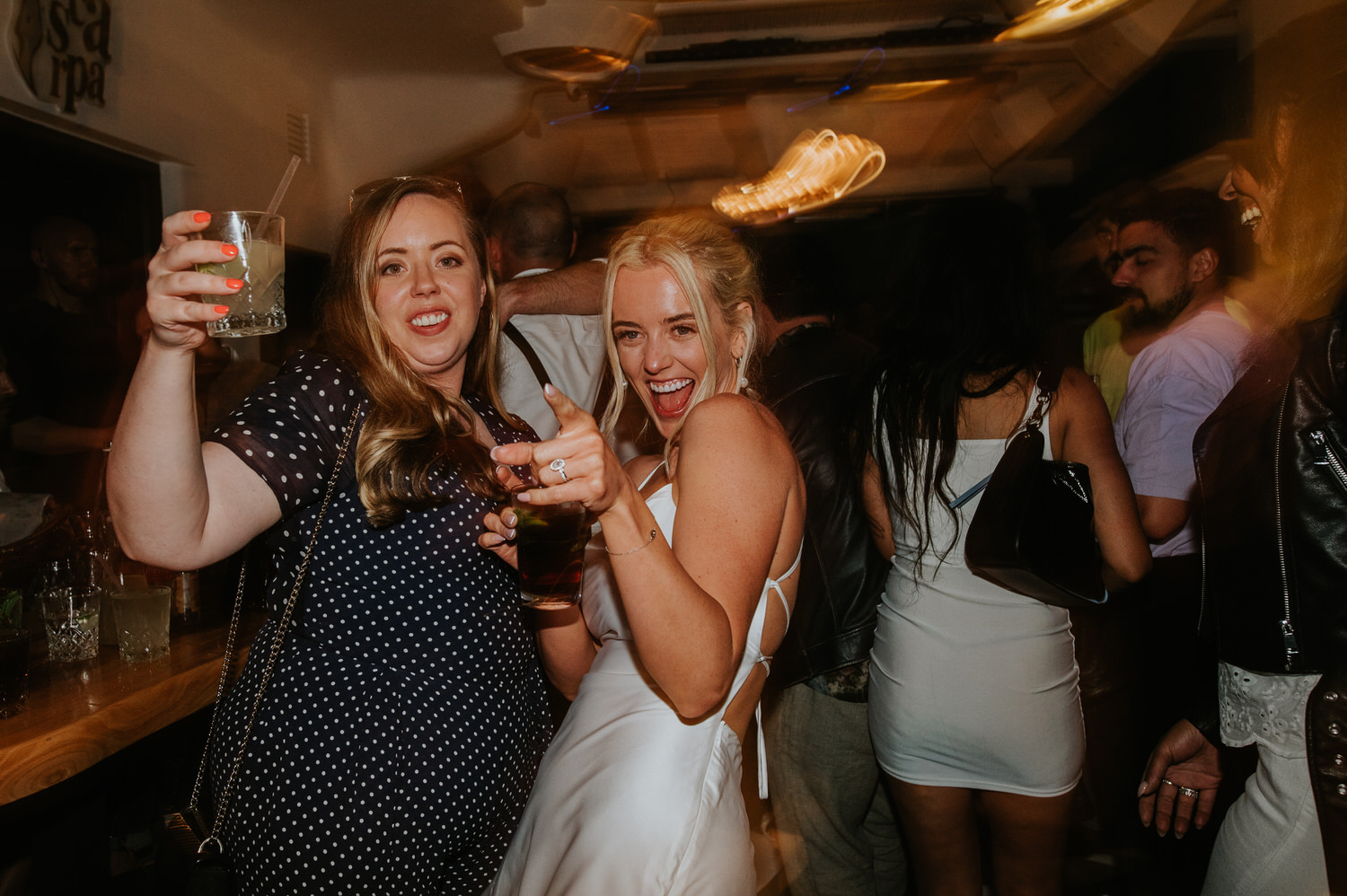 Mykonos wedding photographer: bride and a friend giving us the feels of the night on the dance floor.