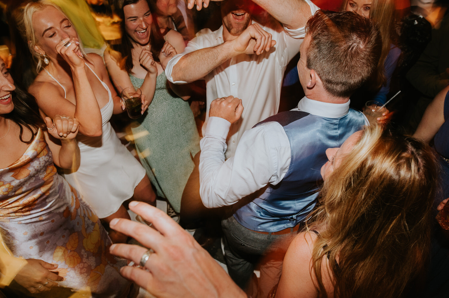 Mykonos wedding photographer: bride and guests on the dance floor at Scarpa bar for her Mykonos wedding celebration.