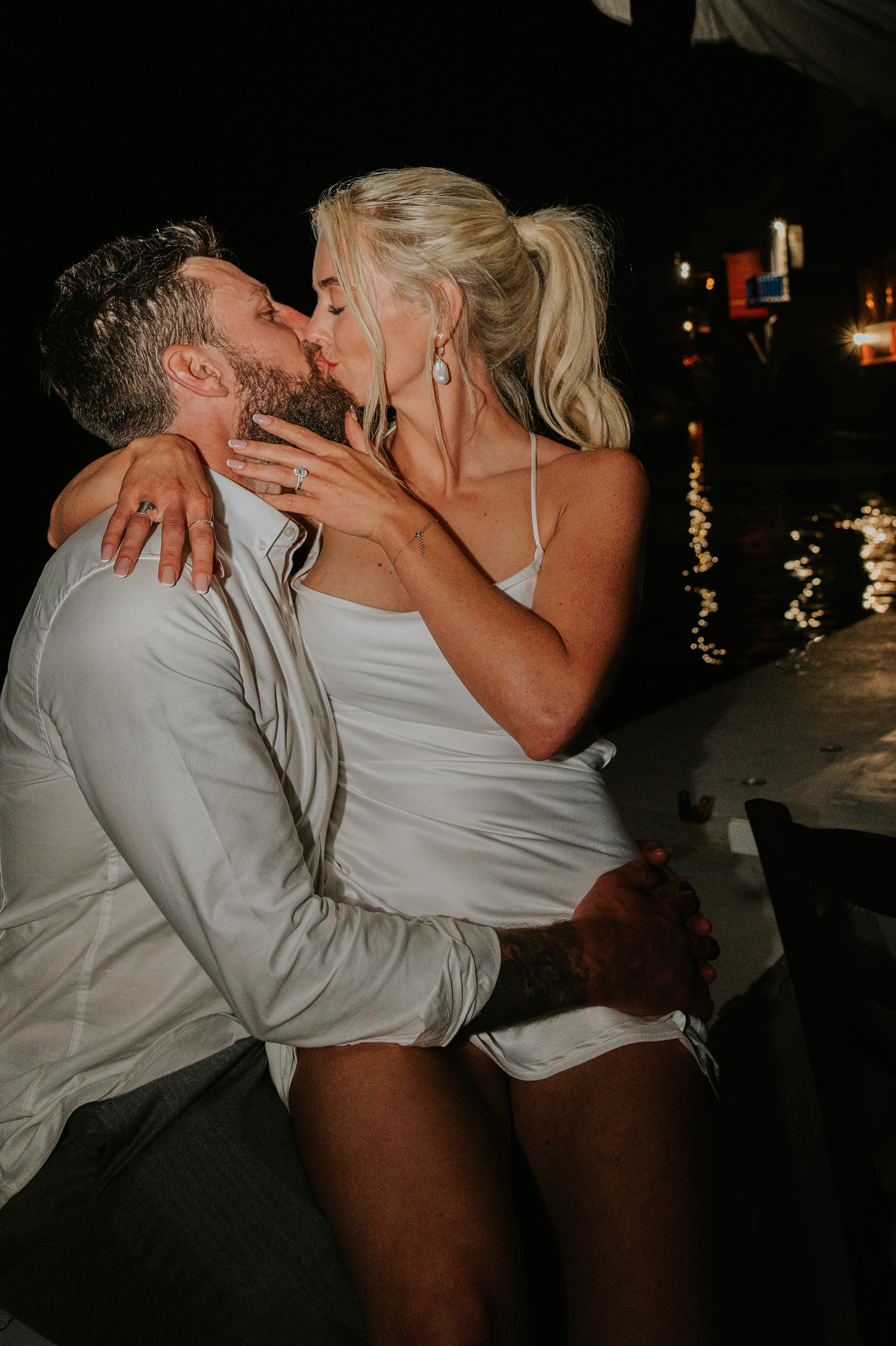 Mykonos wedding photographer: newlyweds kissing in Scarpa bar in Little Venice on their Mykonos wedding.
